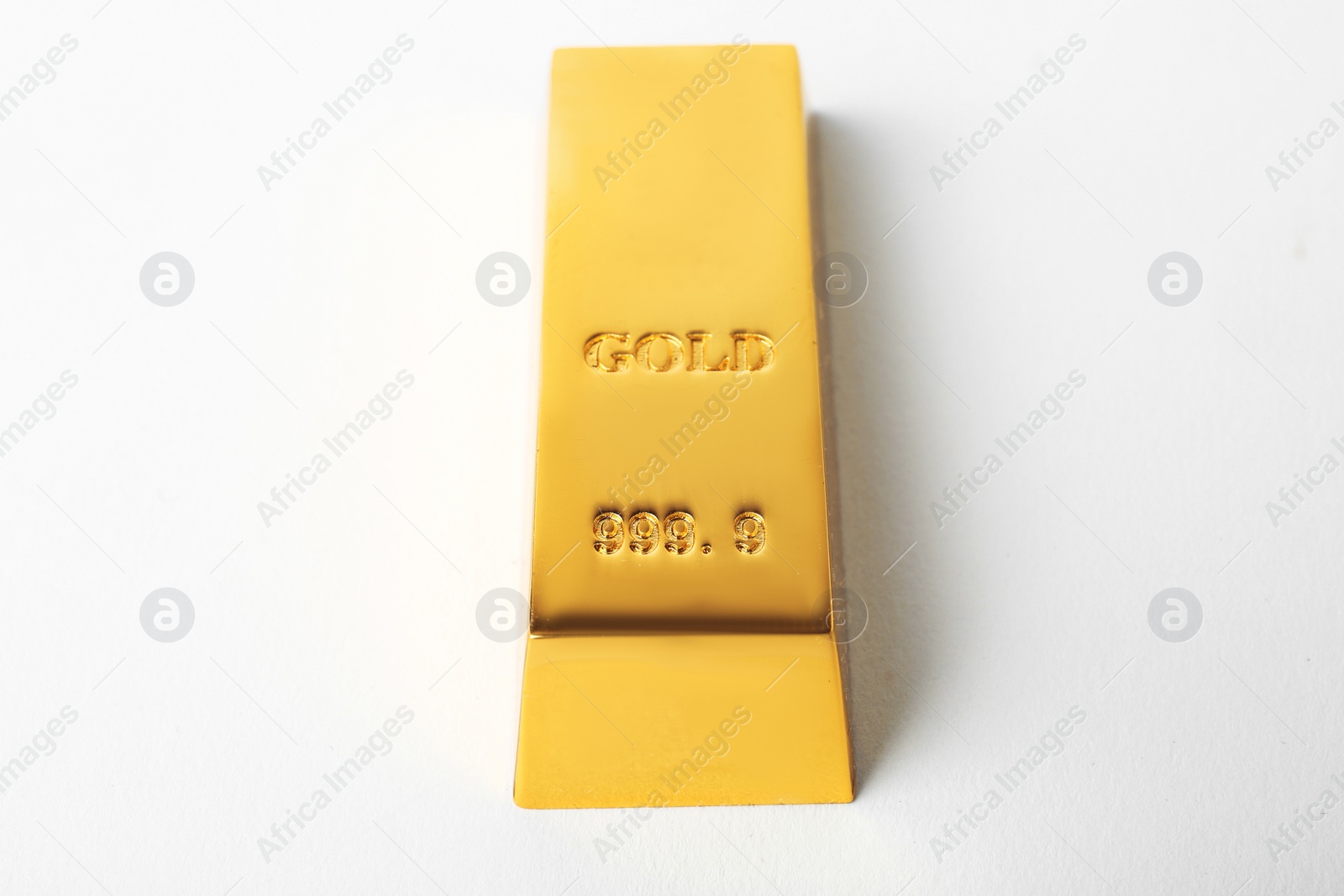 Photo of Precious shiny gold bar on white background