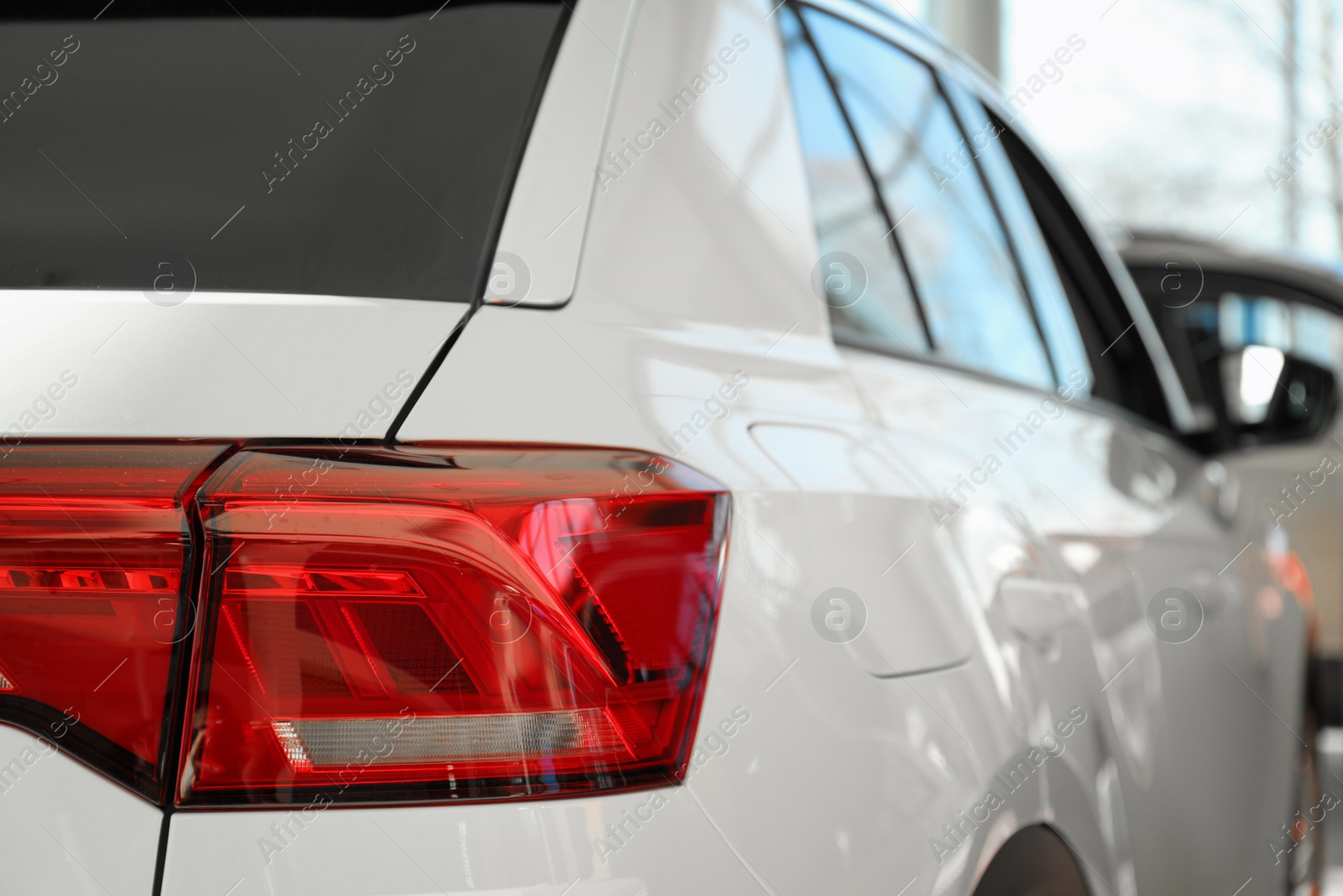 Photo of New luxury car in modern auto dealership, closeup