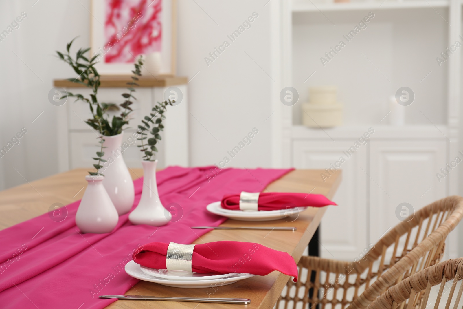 Photo of Beautiful table setting and vases with green branches in dining room