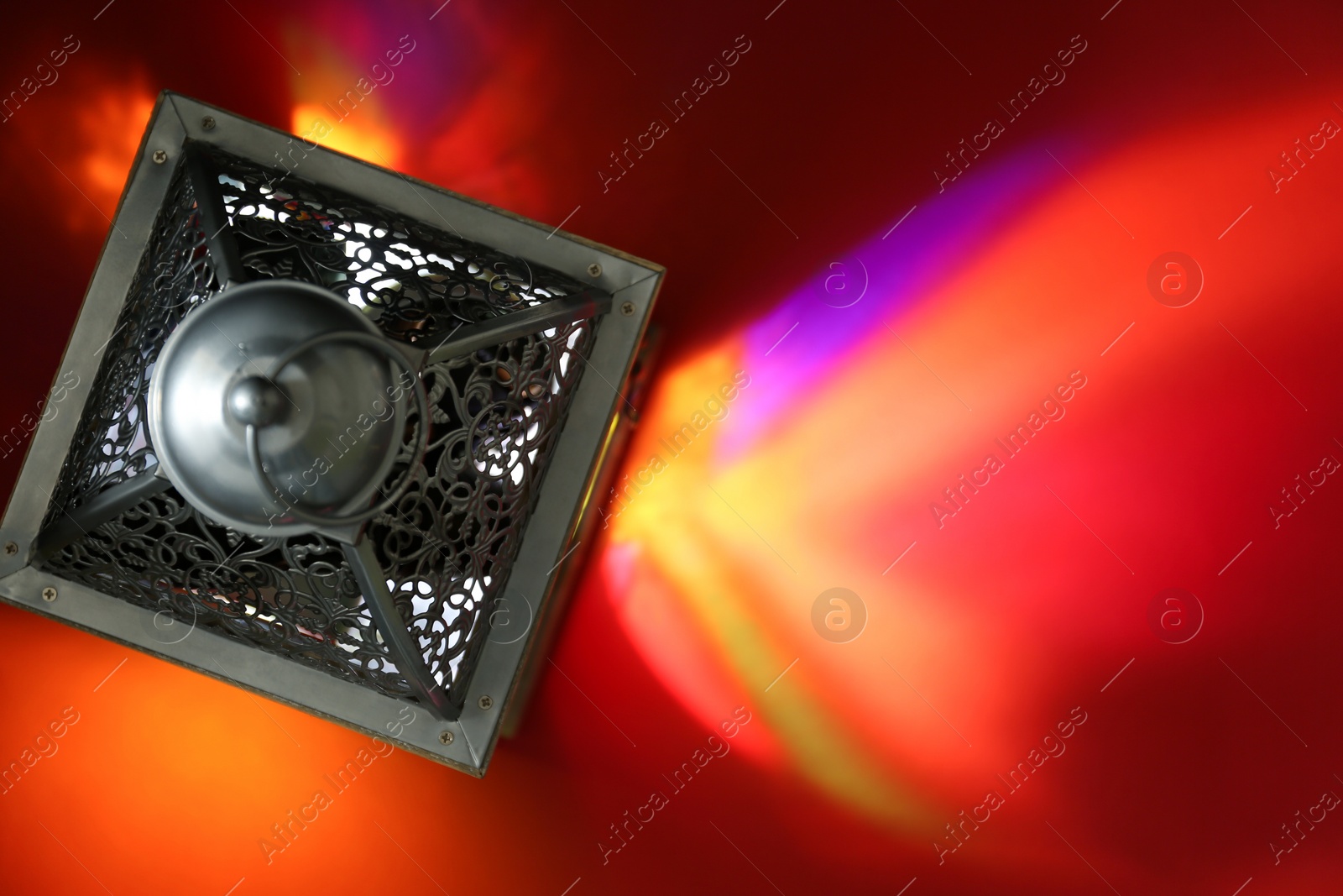 Photo of Decorative Arabic lantern on red background, top view. Space for text