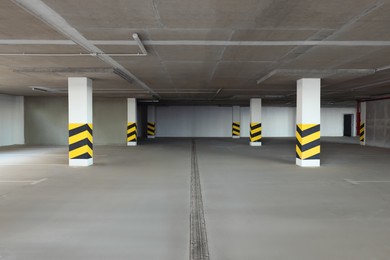 Photo of Empty car parking garage with warning stripes on columns