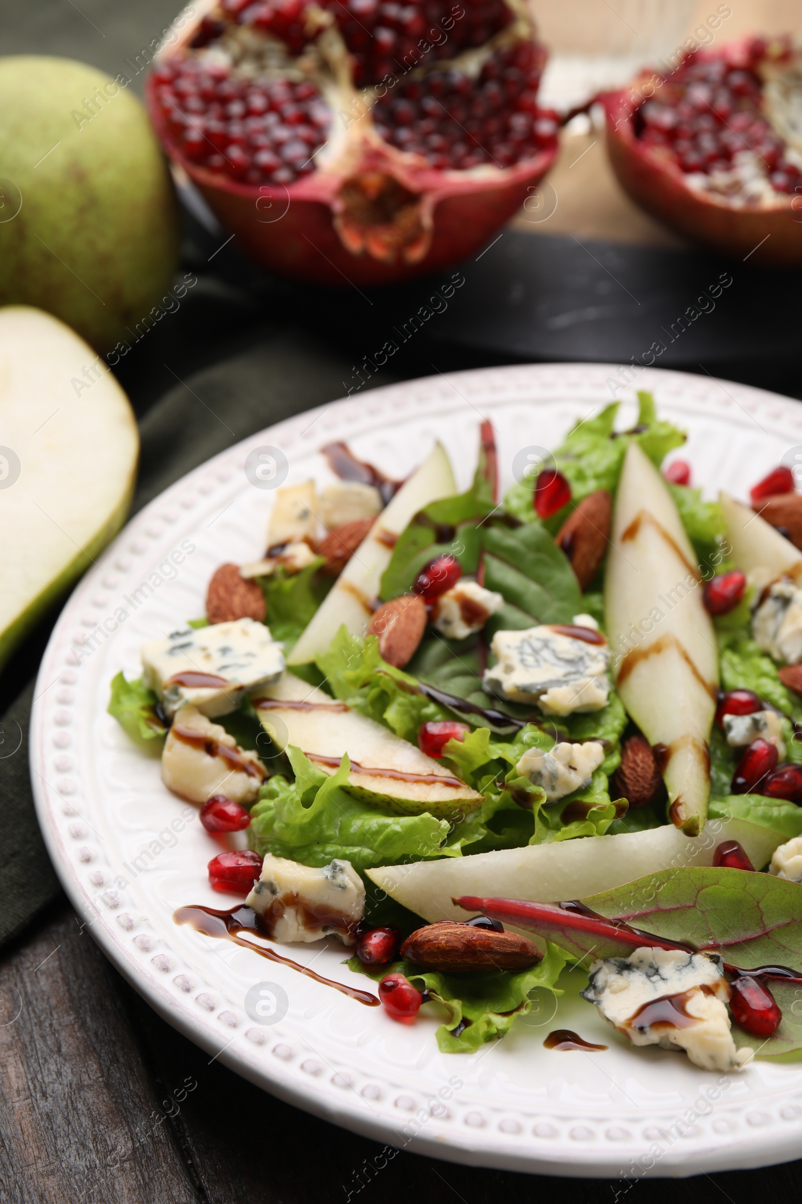 Photo of Delicious pear salad with sauce on wooden table, closeup