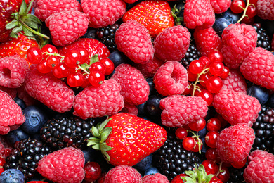 Mix of different ripe tasty berries as background, top view