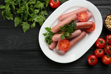 Photo of Delicious vegetarian sausages with parsley, tomatoes and soybeans on black wooden table, flat lay