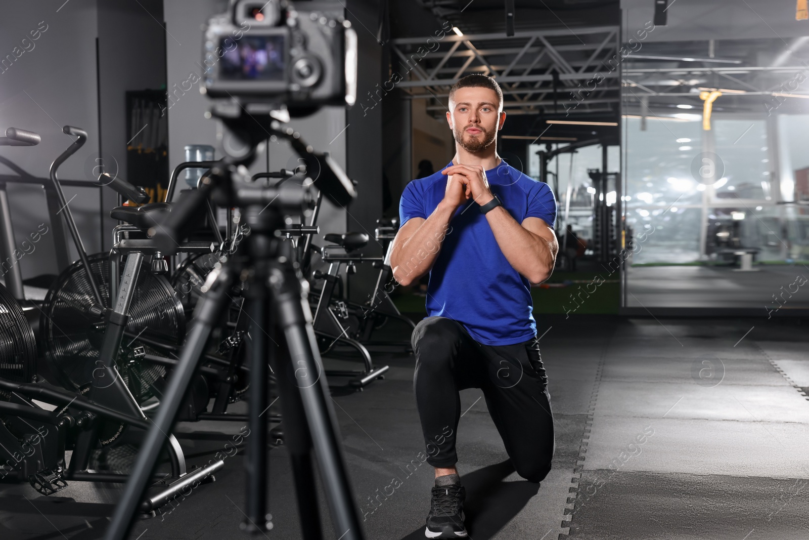 Photo of Man recording workout on camera at gym. Online fitness trainer