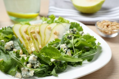 Photo of Fresh salad with pear on table, closeup