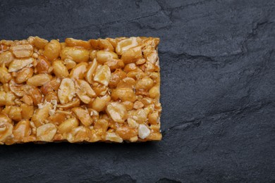 Delicious peanut bar (kozinaki) on black table, top view. Space for text