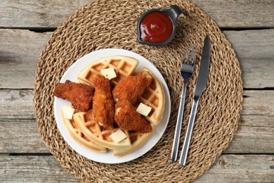 Photo of Delicious Belgium waffles served with fried chicken and butter on wooden table, top view