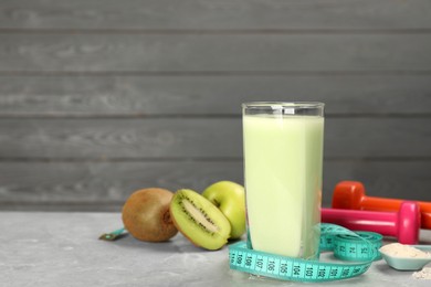 Photo of Tasty shake, measuring tape, powder, fruits and dumbbells on light gray marble table, space for text. Weight loss