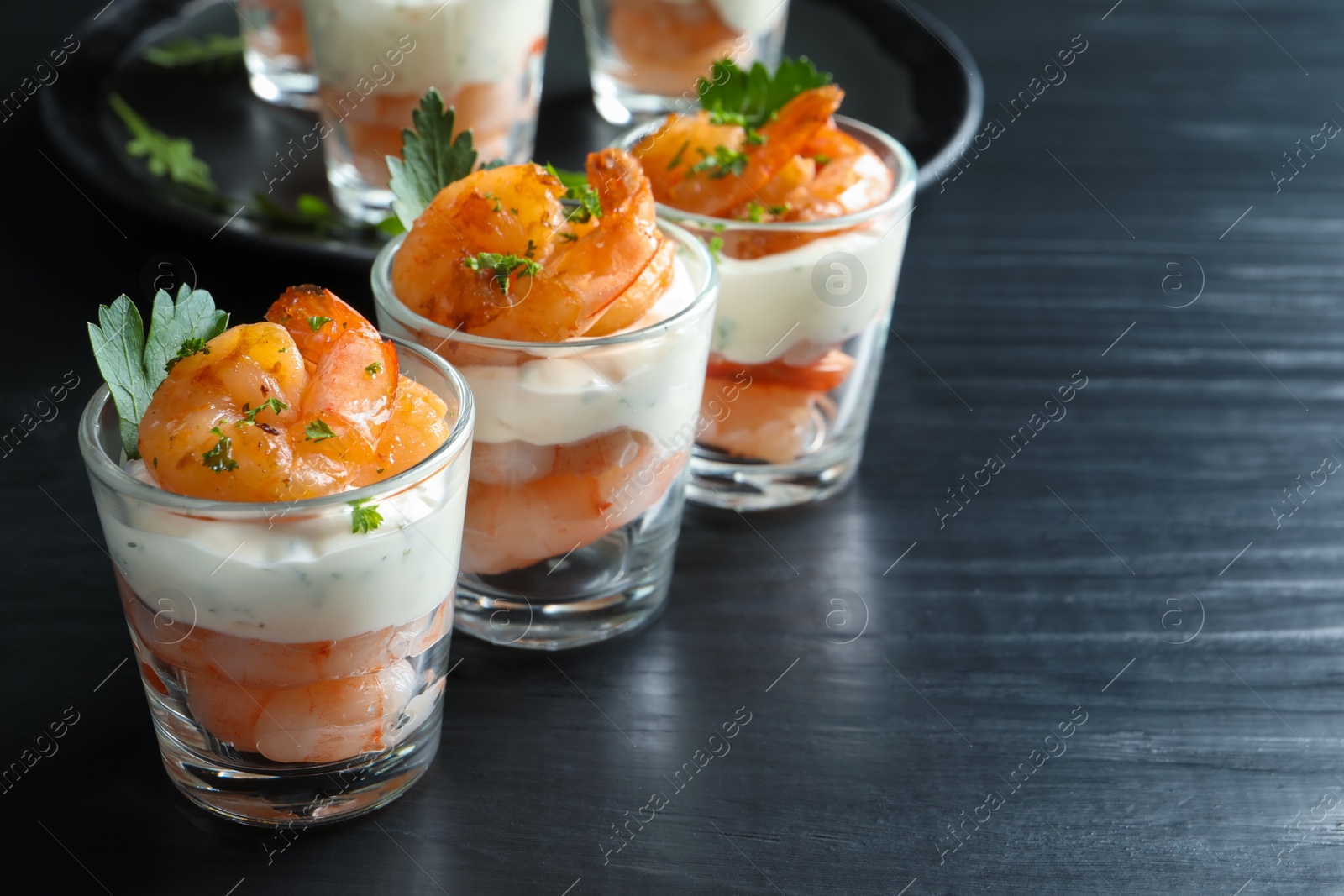 Photo of Glasses with fried shrimps and sauce on wooden background