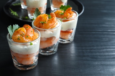 Glasses with fried shrimps and sauce on wooden background