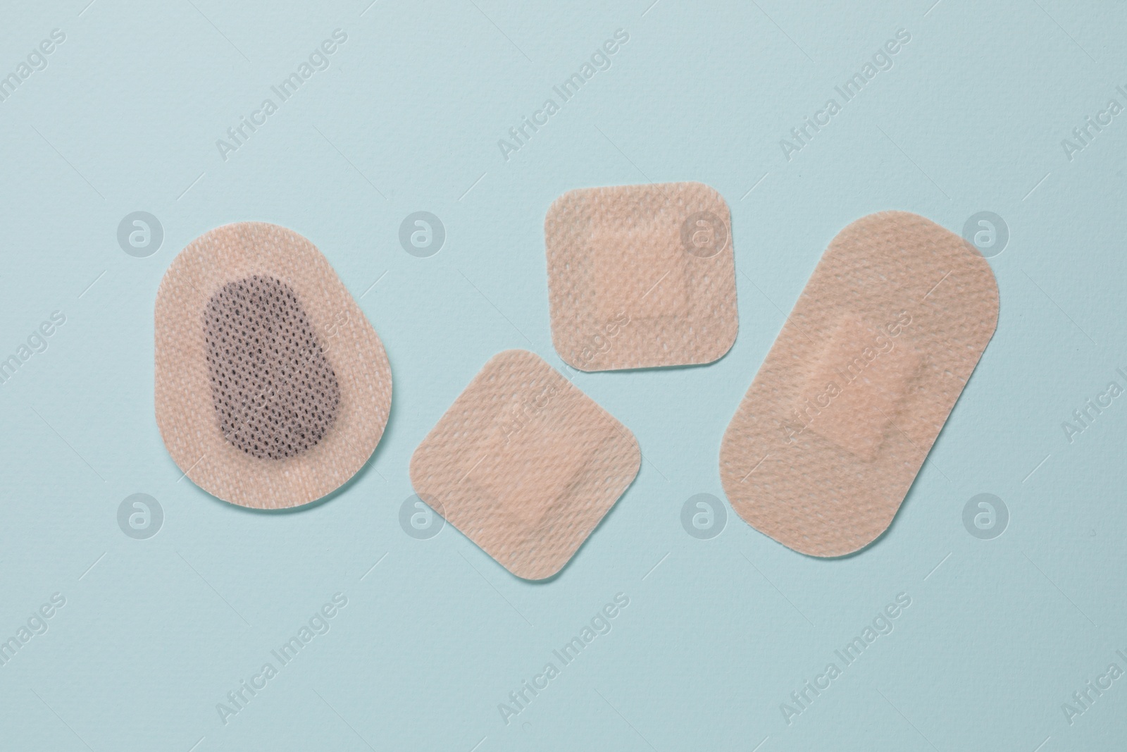 Photo of Contraceptive patches on light blue background, flat lay