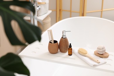 Different personal care products and accessories on bath tub in bathroom