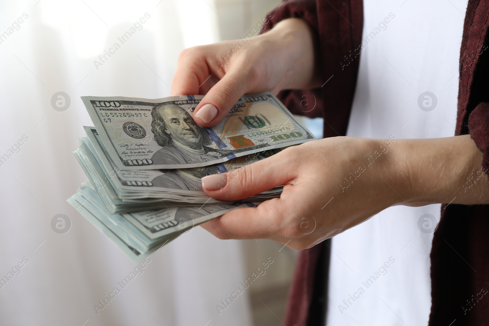 Photo of Money exchange. Woman counting dollar banknotes on blurred background, closeup