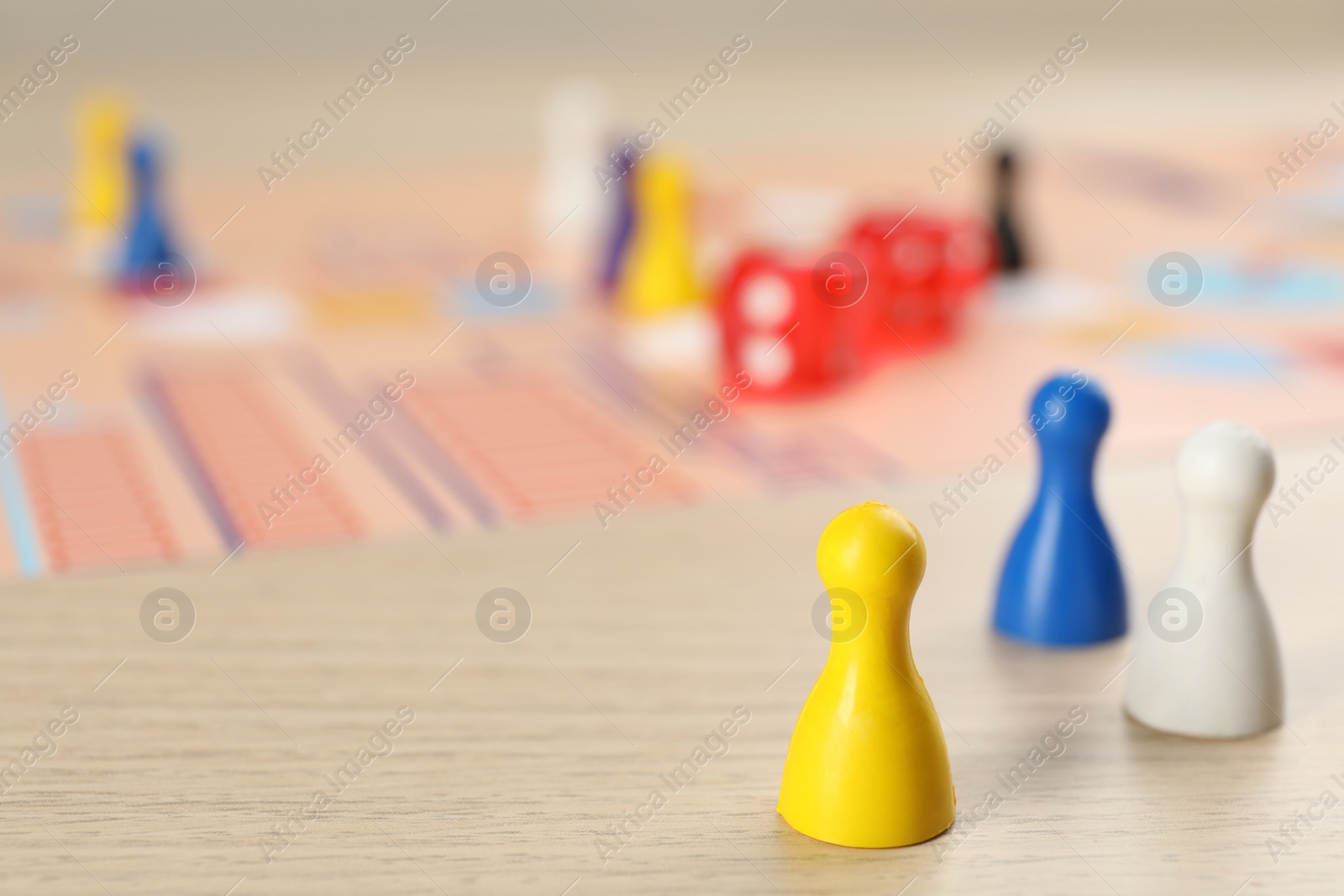 Photo of Closeup view of colorful pawns on wooden table, space for text. Board game