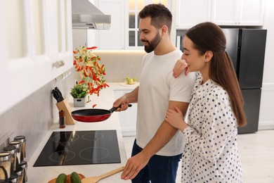 Photo of Happy lovely couple cooking together in kitchen