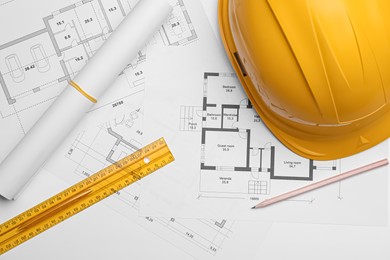 Photo of Flat lay composition with blueprints and hardhat on white background