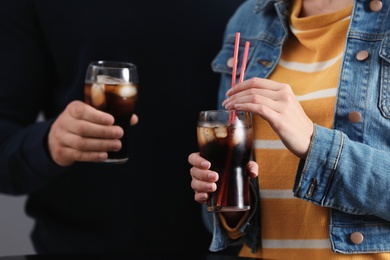 People holding glasses of cola with ice, closeup