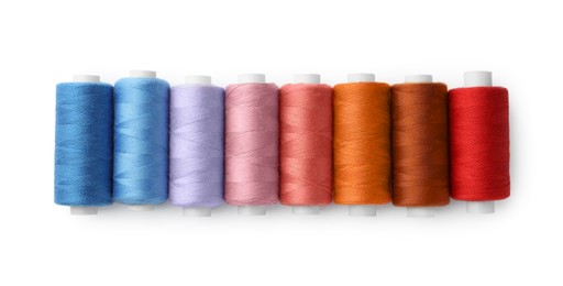 Set of different colorful sewing threads on white background, top view