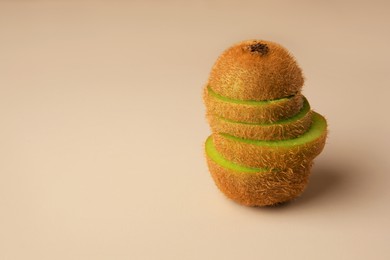 Photo of Sliced fresh kiwi on beige background, space for text