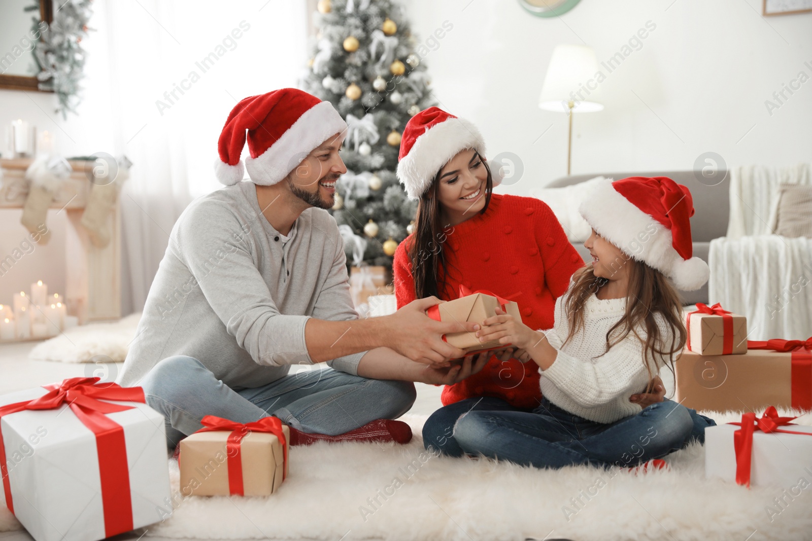 Photo of Happy family with Christmas gifts on floor at home