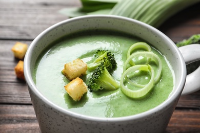 Fresh vegetable detox soup made of broccoli with croutons in dish on table, closeup