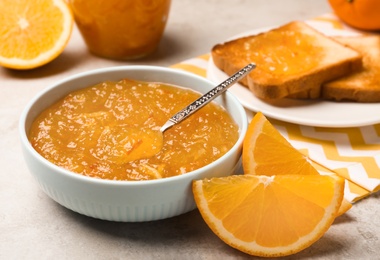 Delicious orange marmalade in bowl on light grey table