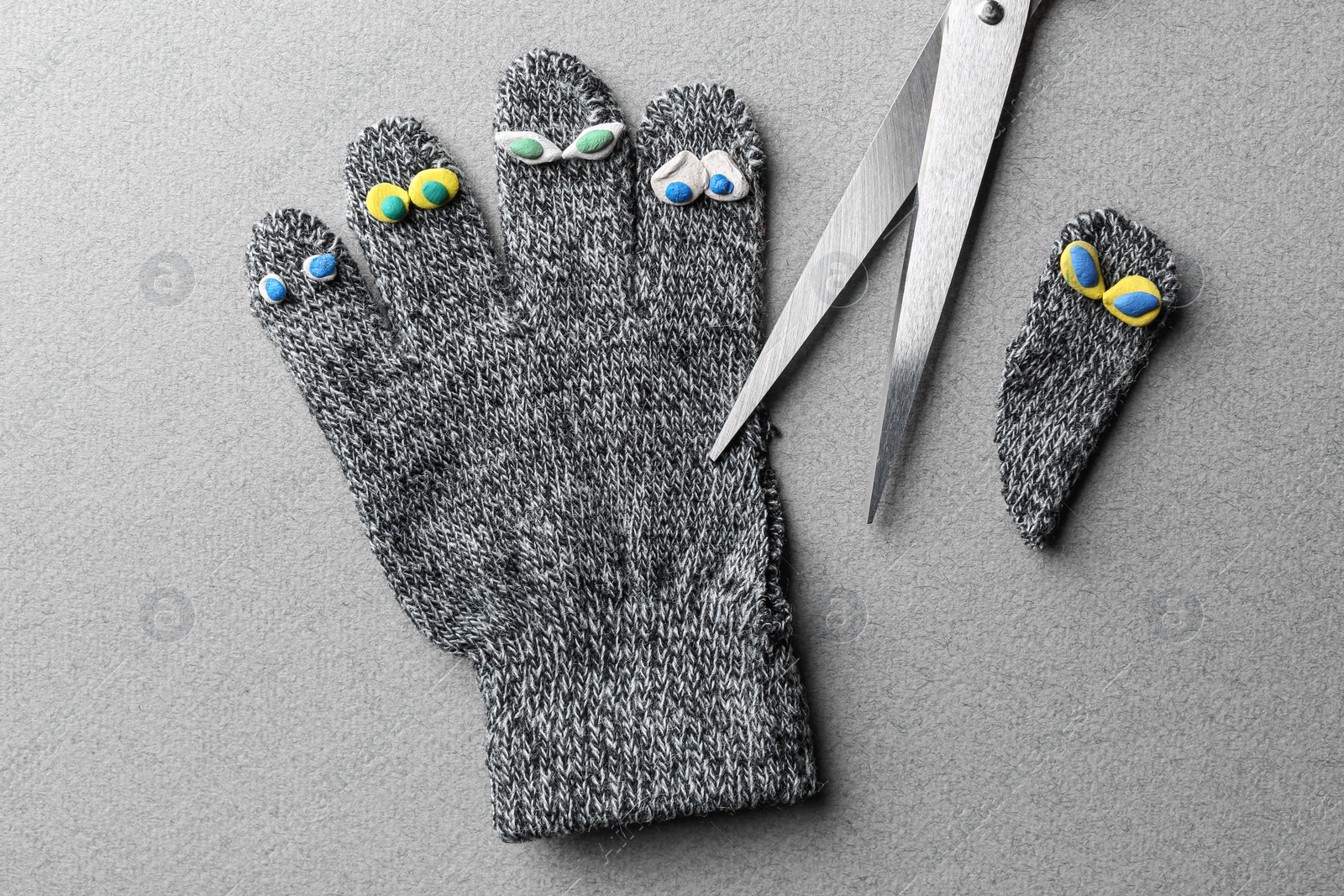 Photo of Divorce concept. Knitted glove and scissors on light grey background, flat lay