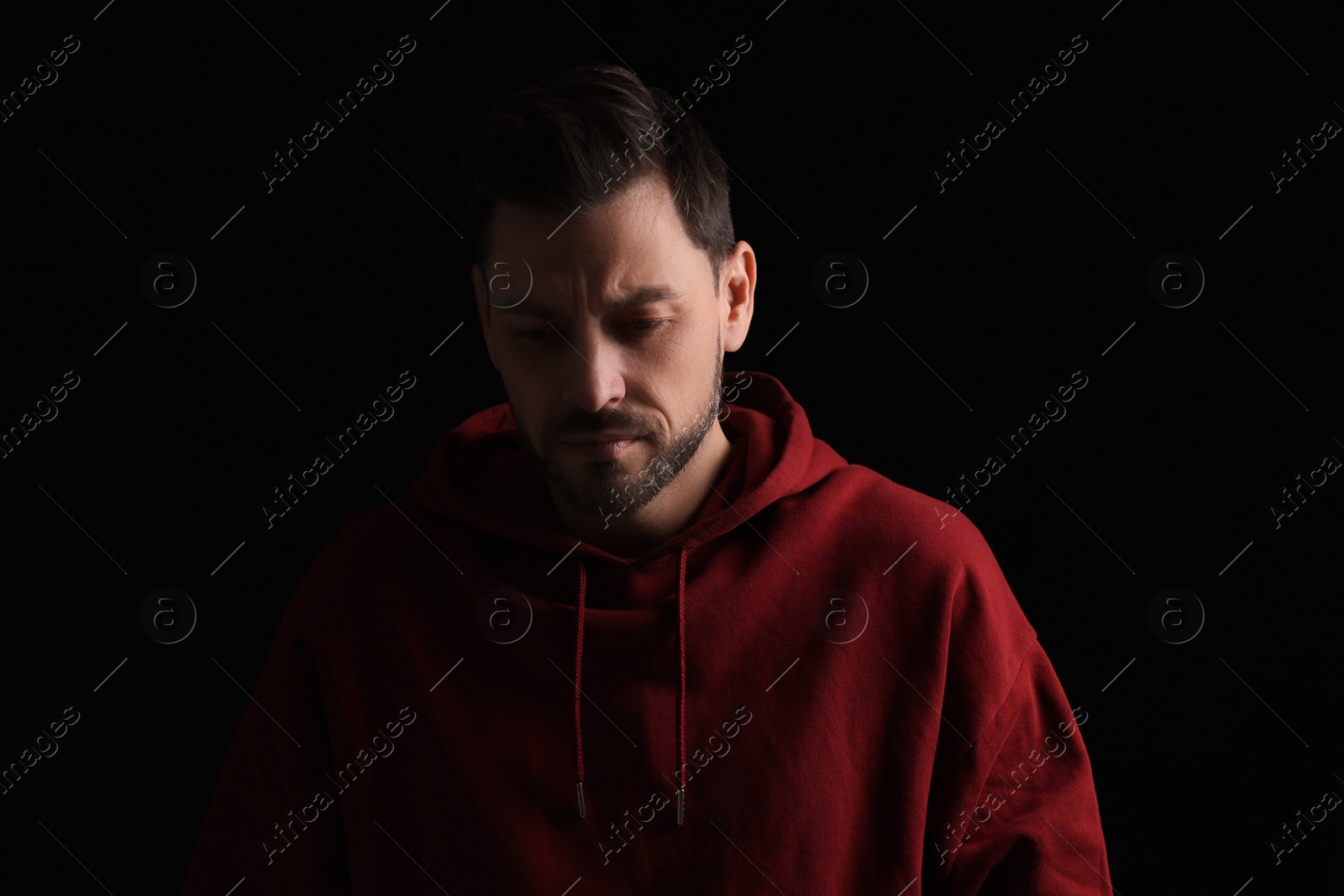 Photo of Portrait of sad man on black background