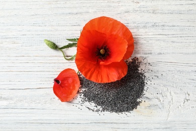 Poppy seeds and flower on white wooden table, flat lay