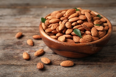 Tasty organic almond nuts in bowl on table