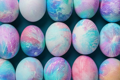 Photo of Many decorated Easter eggs on turquoise background, flat lay