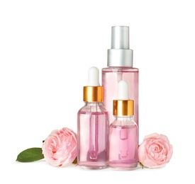 Photo of Bottles with rose essential oil and flowers on white background