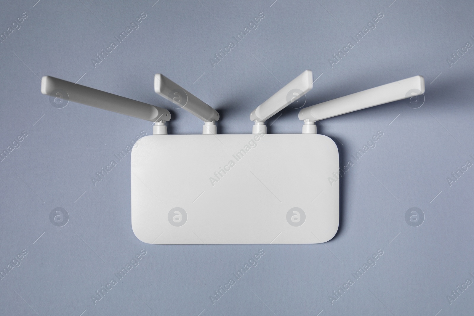 Photo of New stylish Wi-Fi router on grey background, top view