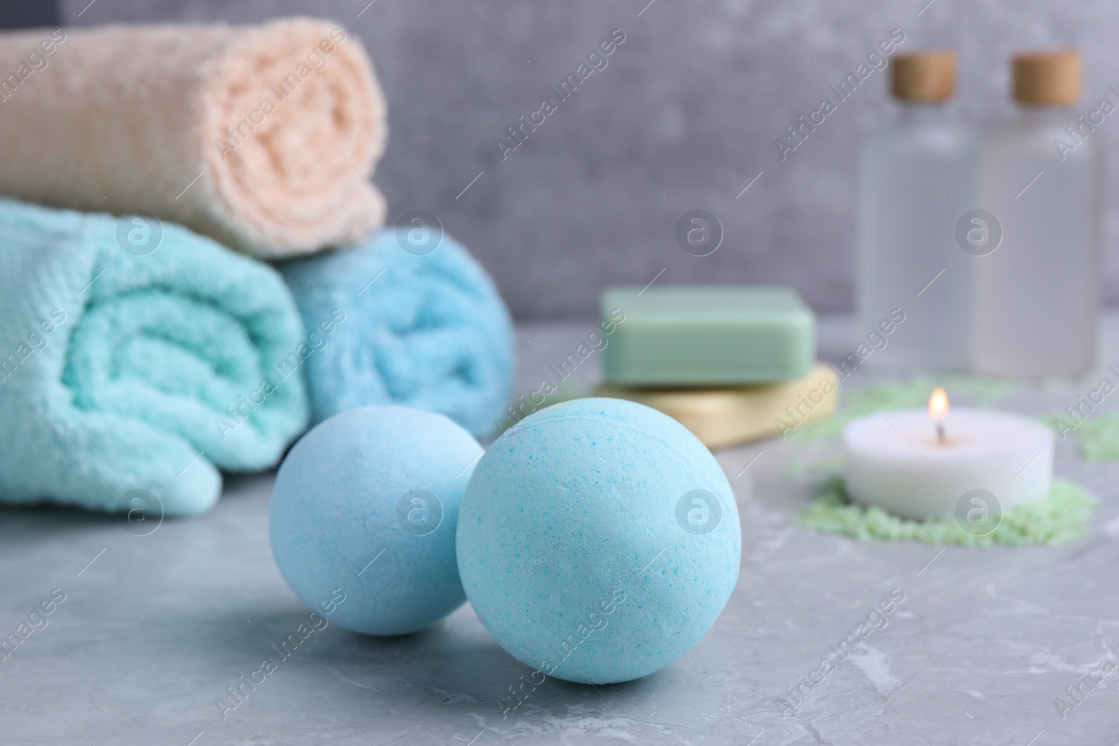 Photo of Beautiful aromatic bath bombs on light grey table, closeup