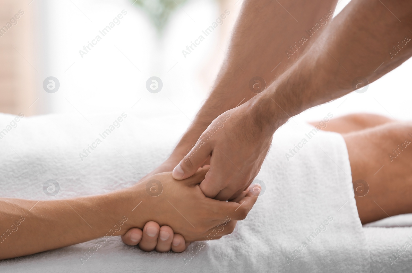 Photo of Young man receiving massage in salon, closeup