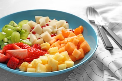 Photo of Plate with fresh cut fruits on table, closeup