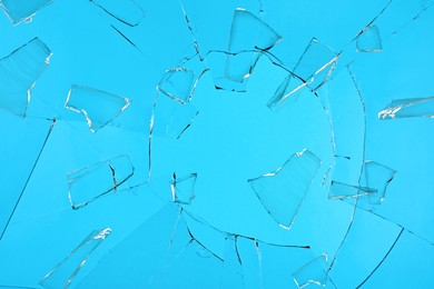 Image of Broken glass with cracks on blue background