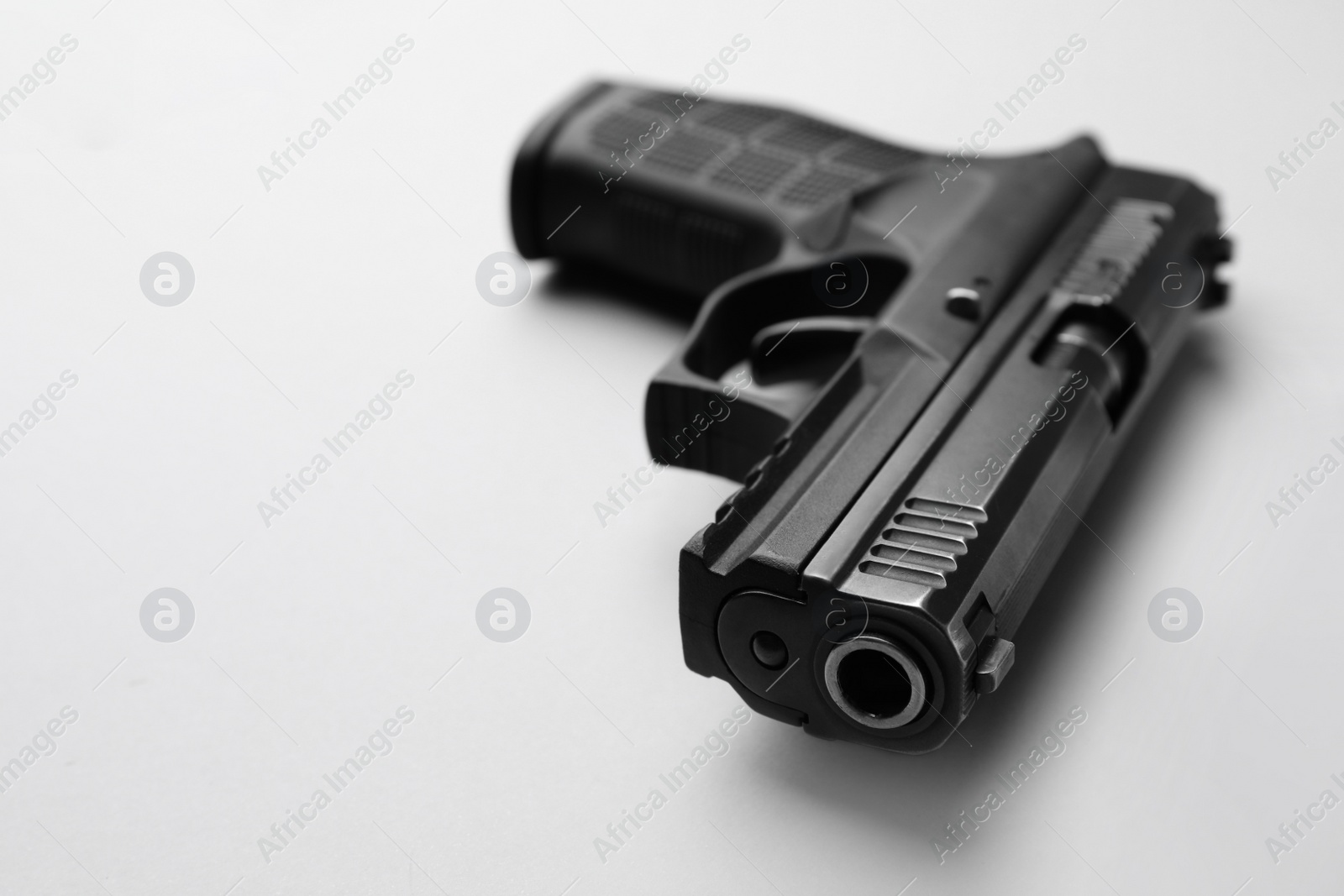 Photo of Semi-automatic pistol on light background, closeup. Space for text