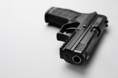 Semi-automatic pistol on light background, closeup. Space for text