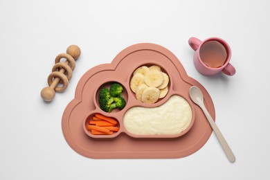 Photo of Healthy baby food in plate, cup with drink and toy on white background, top view