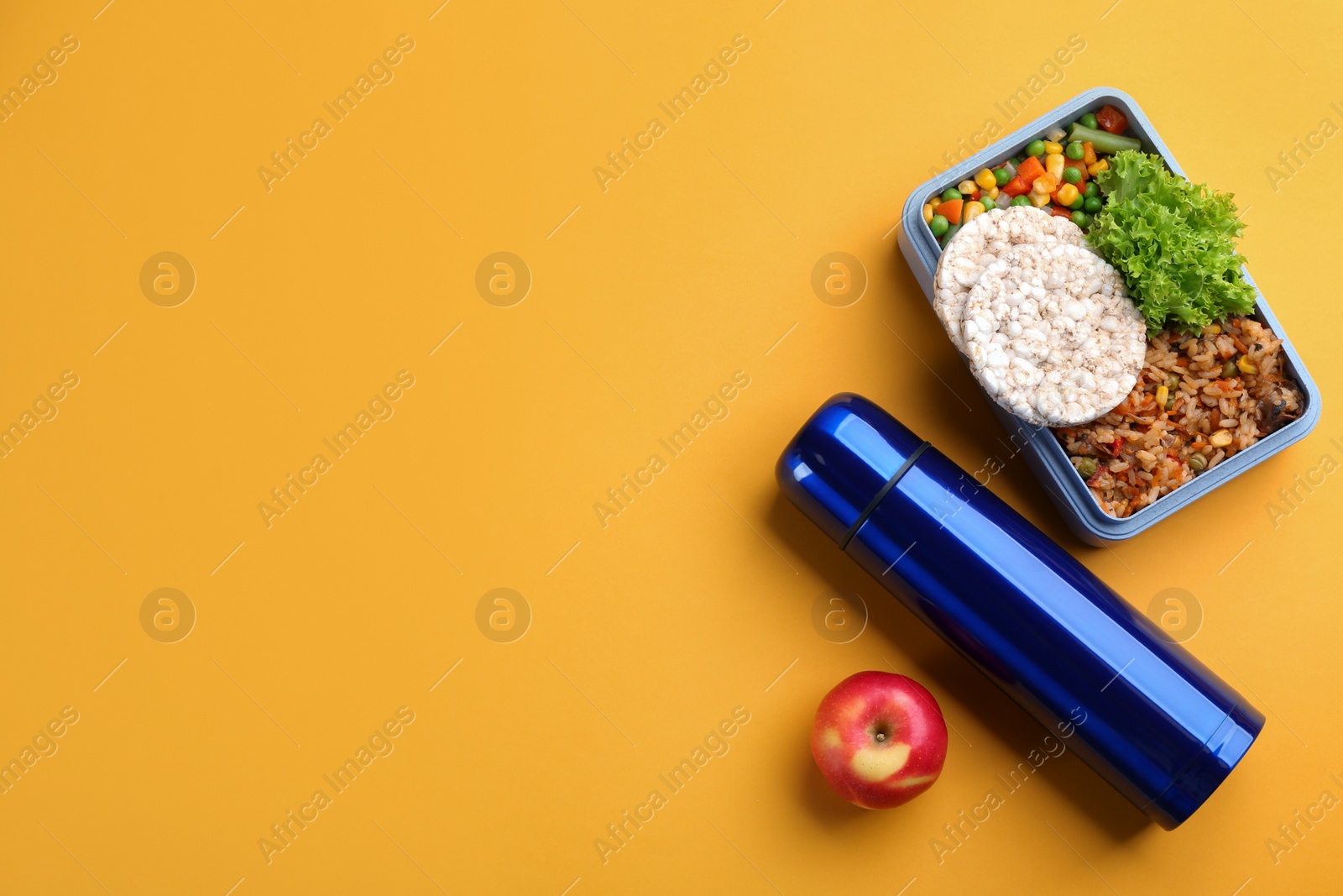Photo of Thermos, lunch box and apple on orange background, flat lay. Space for text