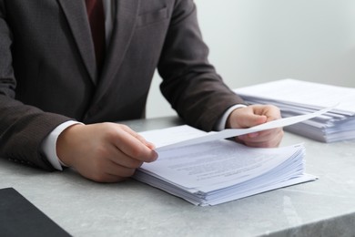 Photo of Man reading document at table in office, closeup