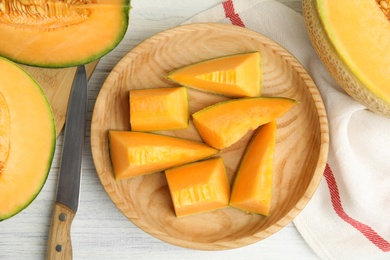 Photo of Tasty fresh cut melon on white wooden table, flat lay