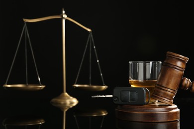 Photo of Car key, gavel near alcohol on black table. Dangerous drinking and driving