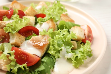 Photo of Delicious fresh Caesar salad on plate, closeup