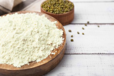 Photo of Plate with mung bean flour and seeds on white wooden table, closeup. Space for text