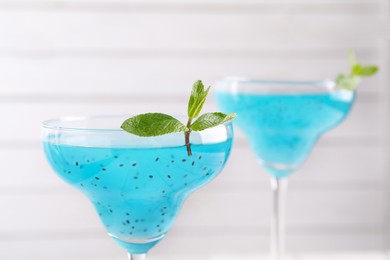 Photo of Delicious cocktail with basil seeds and mint on white background, closeup