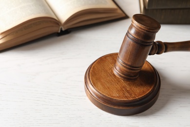 Wooden gavel and books on table, closeup. Law concept