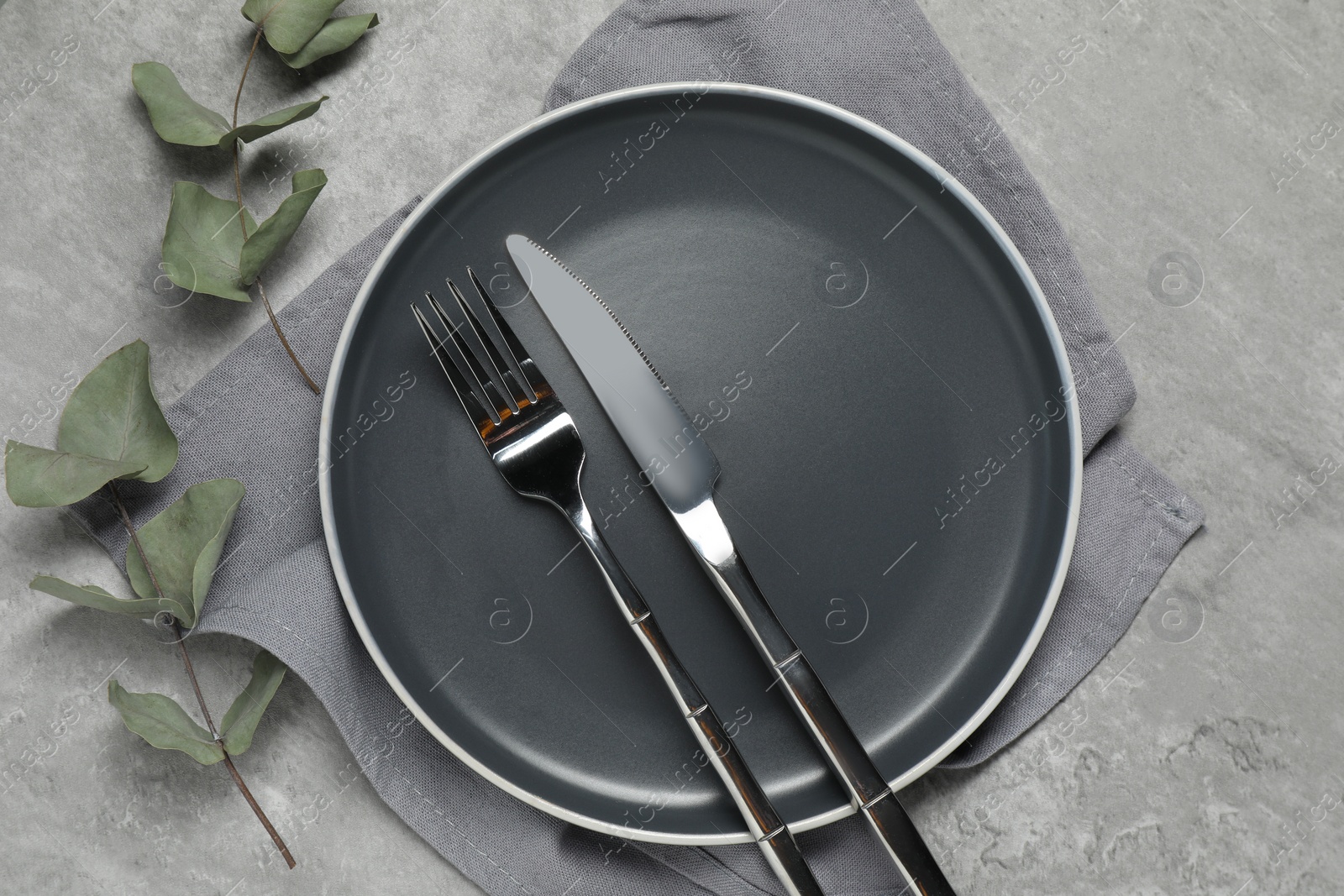 Photo of Stylish setting with elegant cutlery on grey table, top view